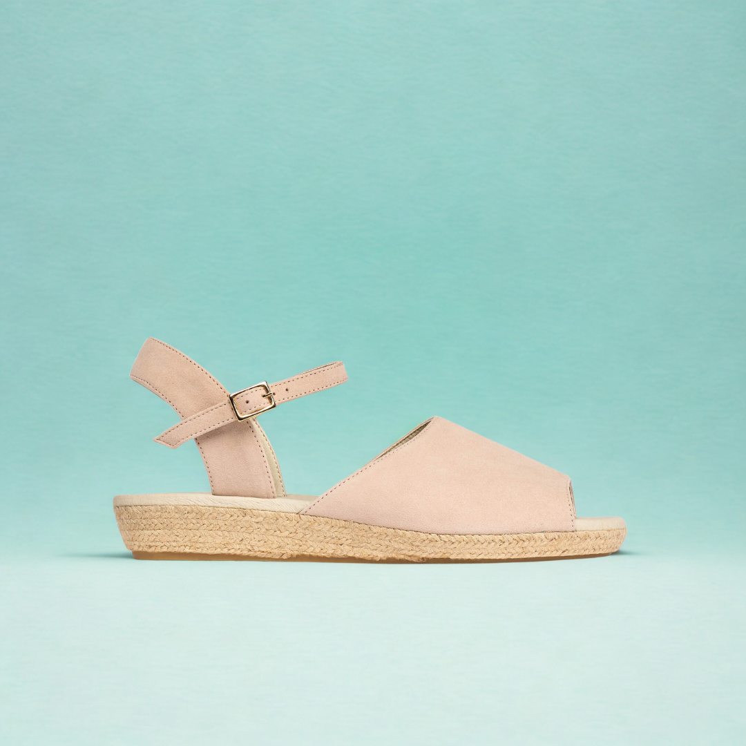 Beige sandal with a jute wedge sole on a light blue background