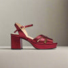 Red high-heeled sandal on a light gray background
