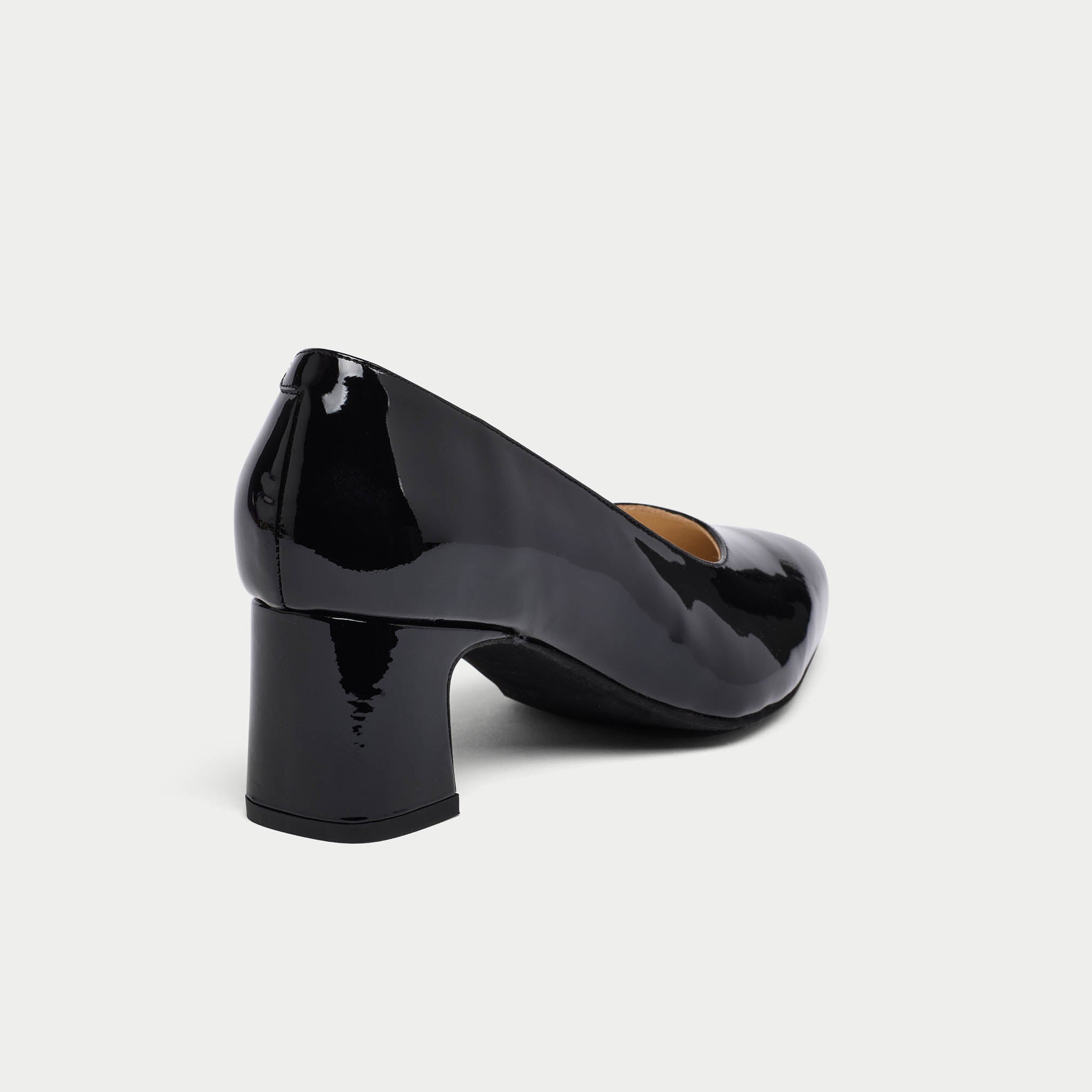 Black patent leather shoe on a light gray background