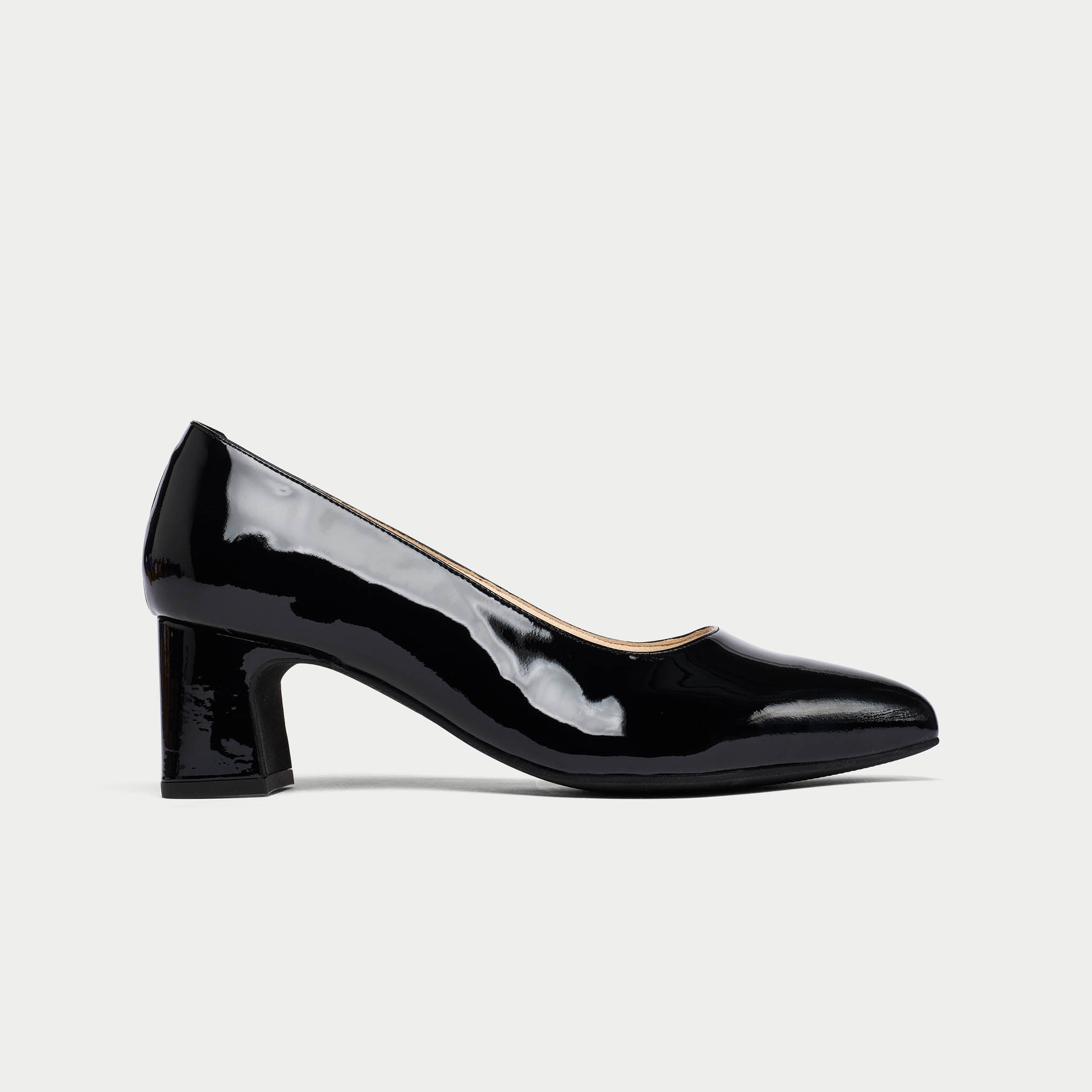 Black patent leather shoe on a light gray background