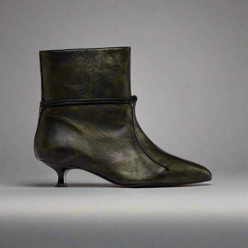 Black leather ankle boot with a pointed toe on a light gray background