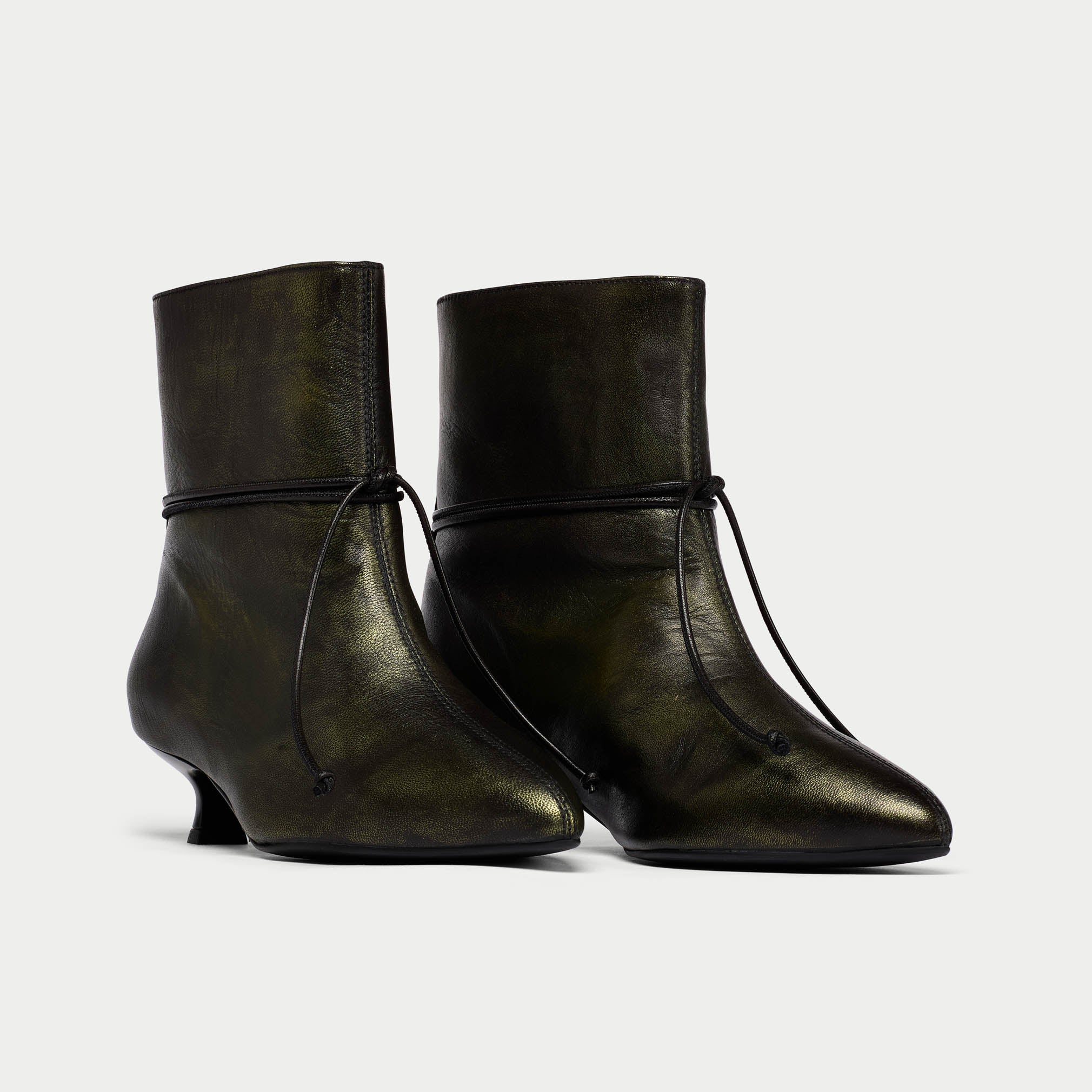 Pair of black leather ankle boots on a light gray background