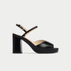 Black sandal with a block heel on a light gray background