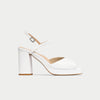 White high-heeled shoe with a block heel on a light gray background