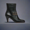 Maya Black ankle boot for bunions with a gold chain on a navy background