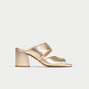Gold open-toe heeled sandal on a light gray background