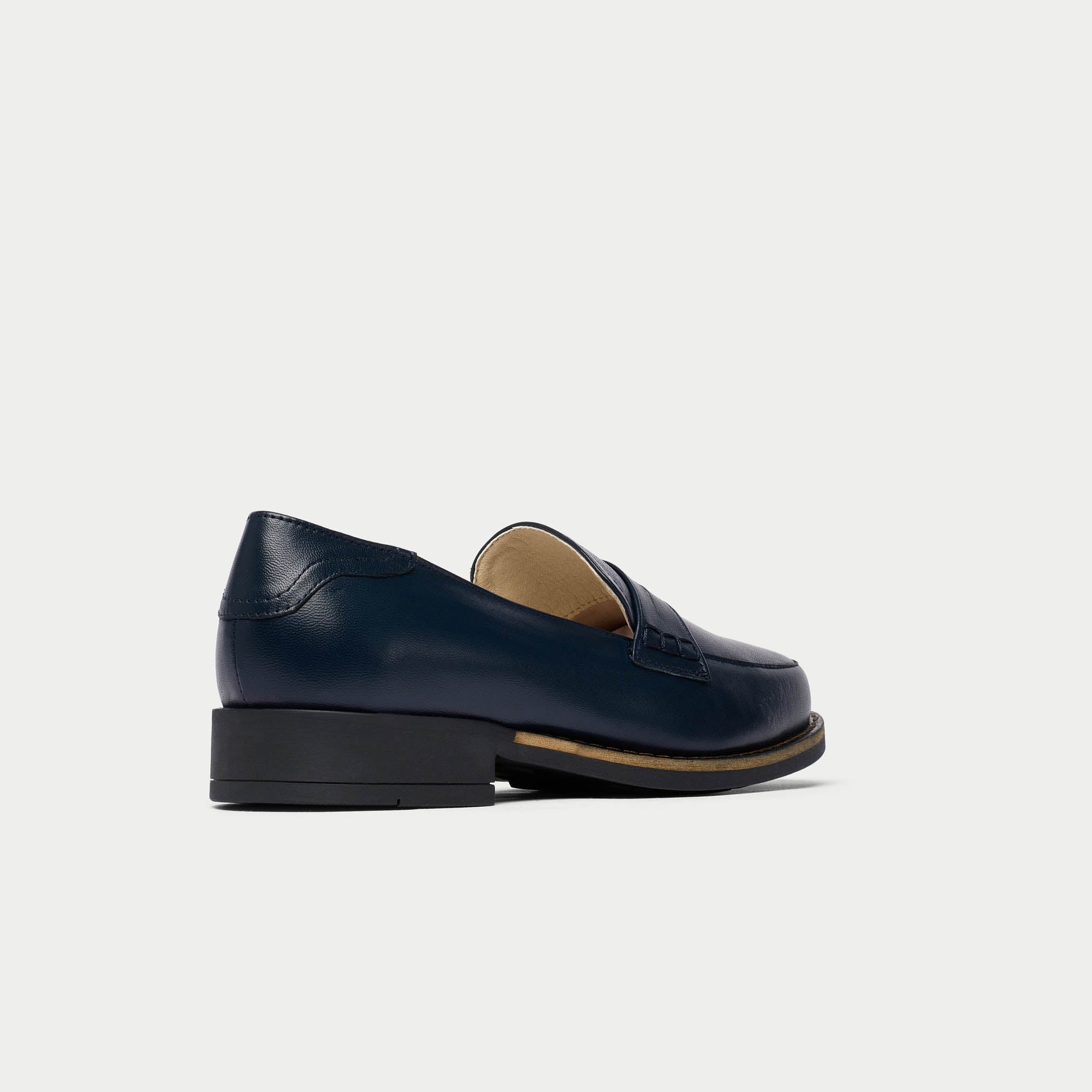 Pair of navy blue loafers on a light gray background