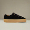 Black Saturn sneaker with tan sole on a light beige background