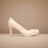Beige high-heeled shoe on a beige background