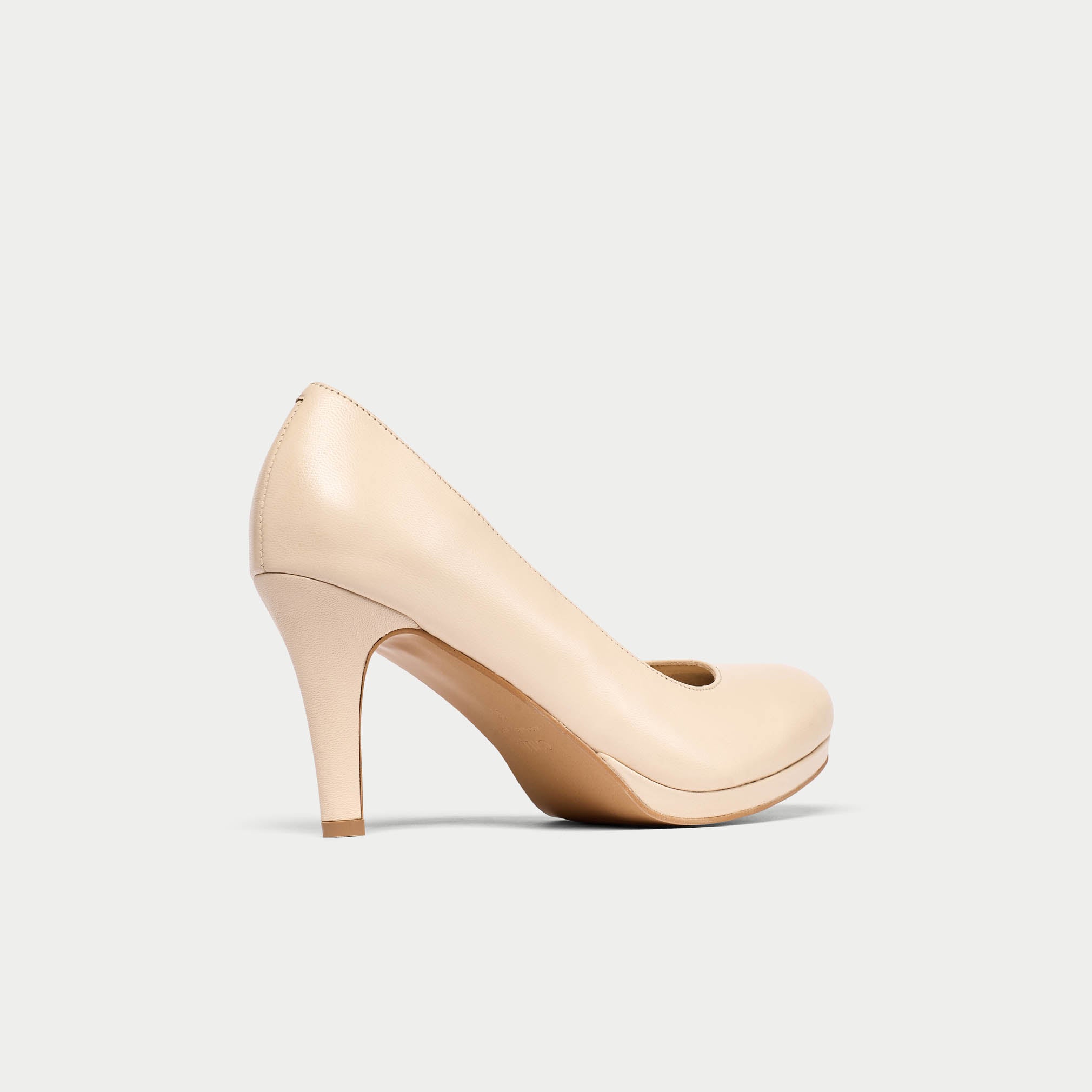 Beige high-heeled shoe on a light gray background
