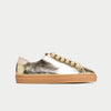 Gold metallic sneaker with tan sole on a light gray background