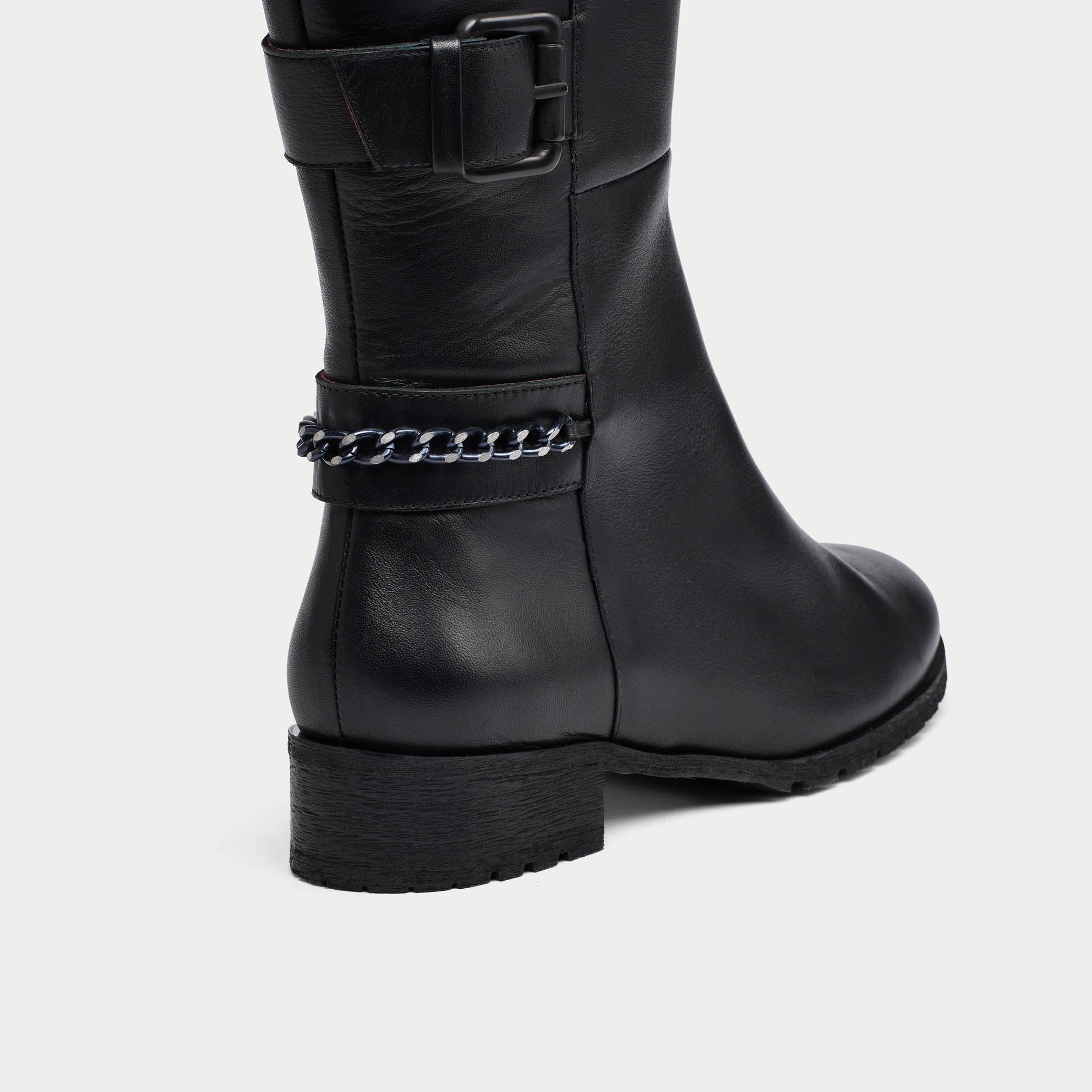 Black leather boot with chain detail on a light gray background