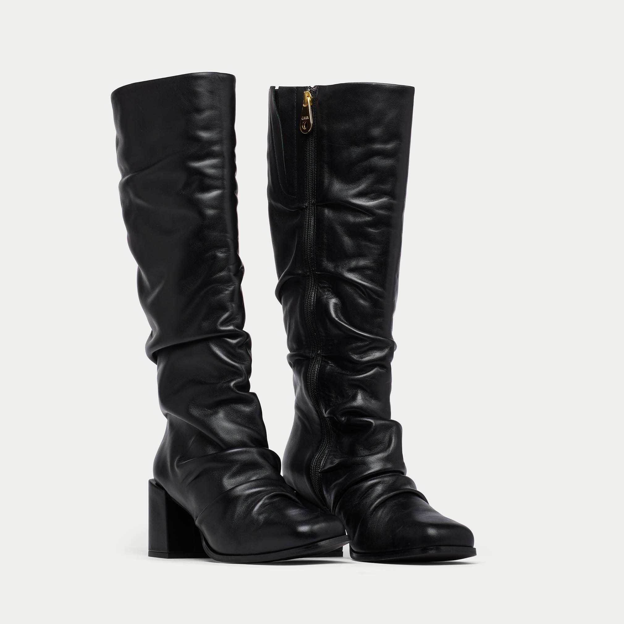Pair of black knee-high boots on a light gray background