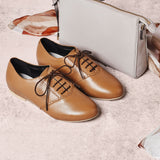 tan leather brogue shoes paired with a handbag
