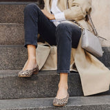 woman sitting on the stairs in leopard shoes