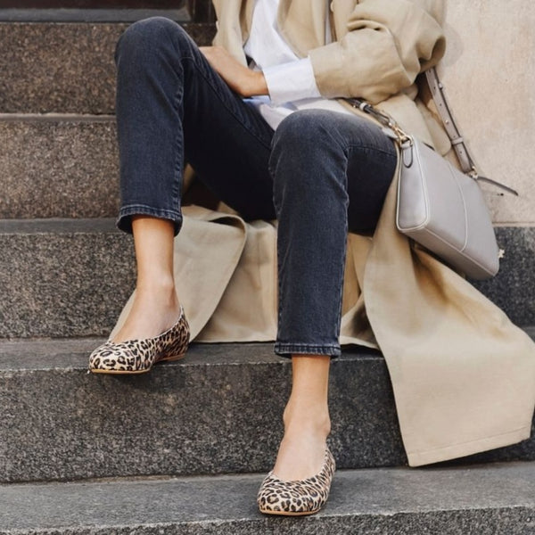 woman sitting on the stairs in leopard shoes
