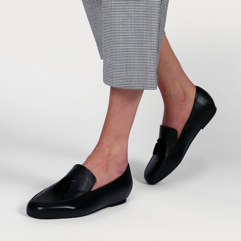 black leather loafers worn on feet