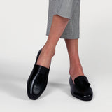 black leather loafers worn on crossed legs